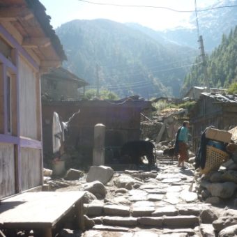 The traditional Tibetan village of Koto, a porters load resting on the right.