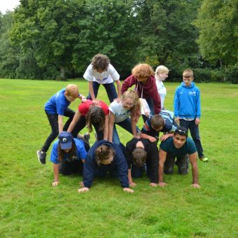 Young people in a human pyramid on grass