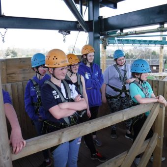 Young people wearing helmets on an activity course