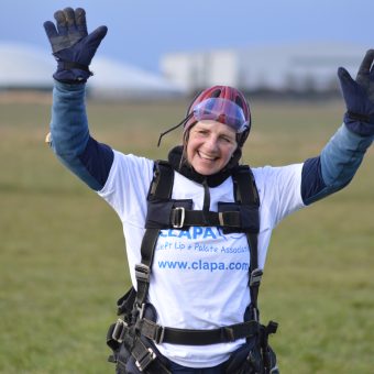 A person standing in an airfiled after a skydive