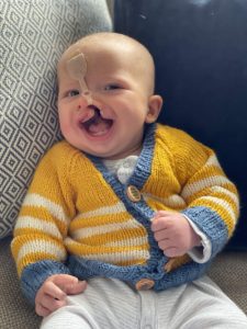 Grandson Joshua in knitted yellow cardigan and smiling face